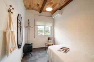 una camera con un letto e una sedia e una finestra di Collblanc Apartment by Olala Homes a Hospitalet de Llobregat