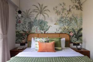 una cama con almohadas coloridas y una pintura en la pared en Soam Villa - Theatre Room, Plunge Pool & Jacuzzi, en Lonavala 31 fotos más