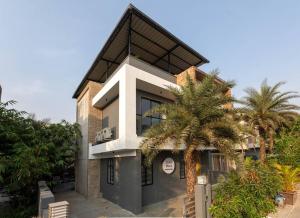 Un edificio con palmeras delante. en Soam Villa - Theatre Room, Plunge Pool & Jacuzzi, en Lonavala