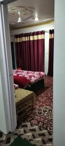 a room with two beds and red curtains at Elizabeth paying guest house Tangmarg gulmarg in Gulmarg