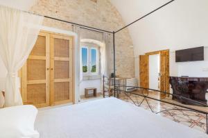 a bedroom with a large bed and a fireplace at Masseria Nicola Casavola in Martina Franca