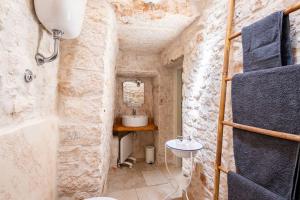 Baño de piedra con lavabo y aseo en I Trulli di Zizì, en Selva di Fasano 82 fotos más