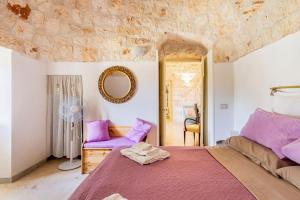 Un dormitorio con una cama grande y un espejo. en I Trulli di Zizì, en Selva di Fasano