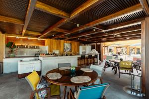 una cucina a pianta aperta e una sala da pranzo con tavoli e sedie di Zendaya Resort Beach Sport & Spa a Búzios