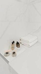 a white bathroom with towels on a counter at Turegatan Top Class Apartment in Stockholm