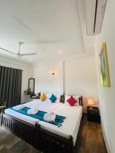 a bedroom with a bed with towels on it at Mama’s Boutique Beach Hotel in Negombo