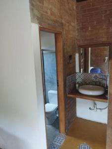 a bathroom with a sink and a toilet at Chalé Pedra Chanfrada 03 in Gonçalves