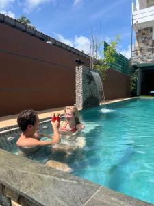 a boy and a girl playing in a swimming pool at Mama’s Boutique Beach Hotel in Negombo