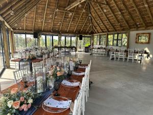 カリナンにあるBeynespoort Farmのテーブルと椅子(花付)が備わる広い客室です。