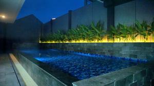 una piscina nel mezzo di un edificio di notte di VNC Alam Sutera Hotel Powered by Archipelago a Dongkal