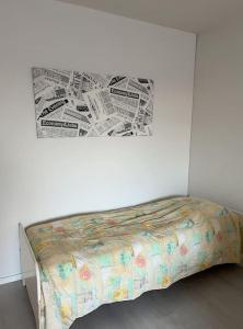 ein Bett in einem weißen Zimmer mit einem Plakat an der Wand in der Unterkunft Tilava kaksio kerrostalossa in Haapajärvi