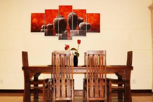 einem Esstisch mit 2 Stühlen und einem Gemälde in der Unterkunft Entire 3 Bed Room Luxurious Apartment in Colombo 8 in Colombo