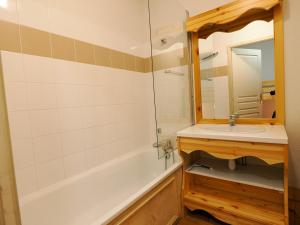 La salle de bains est pourvue d'un lavabo, d'une baignoire et d'un miroir. dans l'établissement Appartement Valfréjus, 3 pièces, 8 personnes - FR-1-468-68, à Valfréjus