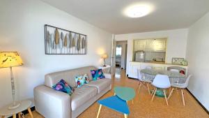 una sala de estar con un sofá y una mesa en Le Neptune, en Sainte-Maxime