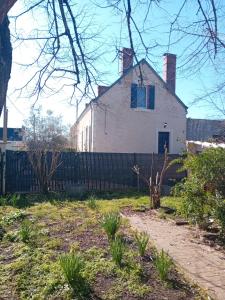 ein weißes Haus mit einem Zaun davor in der Unterkunft Bois d'Yevre in Vierzon