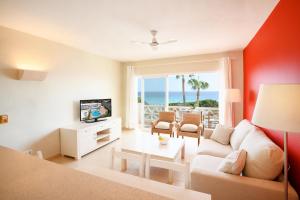 a living room with a couch and a tv and the ocean at Apartamento 5 en Primera linea de mar in Santo Tomás