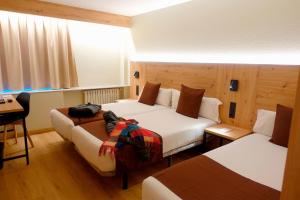 um quarto de hotel com duas camas e uma mesa em Comtes d’Urgell em Andorra-a-Velha