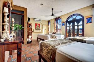 una habitación de hotel con 4 camas y una mesa en Hotel Cielo en Playa del Carmen