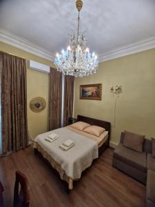sypialnia z łóżkiem i żyrandolem w obiekcie Guest house Lana w mieście Tbilisi City
