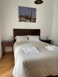 - une chambre avec un lit et 2 serviettes dans l'établissement Apartamento Puerta del Perdón, à Constantina
