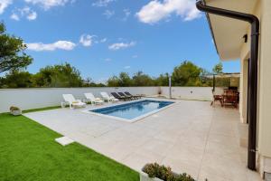 un patio trasero con piscina y césped en Villa Shaula 1 en Bilice
