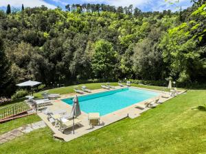 - une piscine avec des chaises et des parasols dans la cour dans l'établissement La Ferriera Exclusive Resort - Pool & Waterfall, à Loro Ciuffenna
