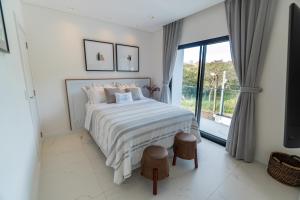 Un dormitorio blanco con una cama y una ventana grande. en Kamabre Luxury Villas, en Foz do Iguaçu 81 fotos más