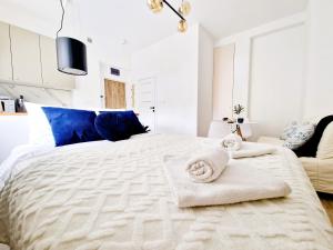 biała sypialnia z dużym łóżkiem i ręcznikami w obiekcie J&W Apartments Grójecka Glam Flat w Warszawie