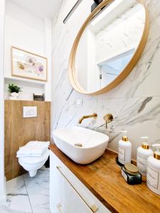 a bathroom with a sink and a mirror at J&W Apartments Grójecka Glam Flat in Warsaw