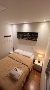 a bedroom with a bed and a picture on the wall at Apartamento Maravilhoso Perfeito in Sao Paulo