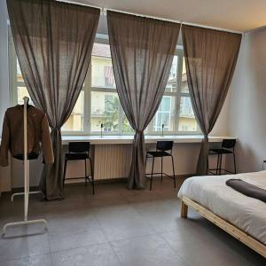 Un dormitorio con una cama y una mesa y ventanas. en La Casetta, en Alba