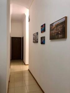 a hallway with a white wall with pictures on it at Tbilisi Sweet Hotel in Tbilisi City