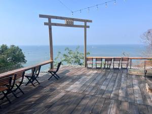 una terraza de madera con bancos y vistas al océano. en Nam Kha Homestay, en Vung Tau
