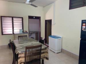 d'une salle à manger avec une table, des chaises et un réfrigérateur. dans l'établissement Padang Besar Guesthouse Firdaus, à Padang Besar