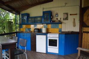 La casita del jardinero في لوس يانوس دي أريداني: مطبخ مع دواليب زرقاء وموقد ابيض