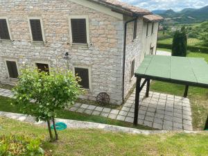 una casa con una mesa verde delante de ella en Villa Colticciola Agriturismo Marche, en Cagli