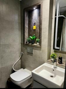 a bathroom with a white toilet and a sink at Luxury Heights with City View and River View in Noida