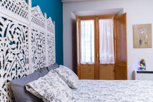 マドリードにあるApartamento Divina Malasañaのベッドルーム1室(白いベッド1台、青い壁付)