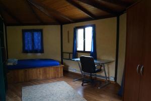 La casita del jardinero في لوس يانوس دي أريداني: غرفة نوم بسرير ومكتب ونافذة