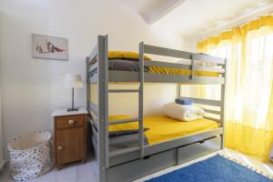 a bedroom with bunk beds with yellow sheets and a blue rug at Belle maison bleu azur in Six-Fours-les-Plages