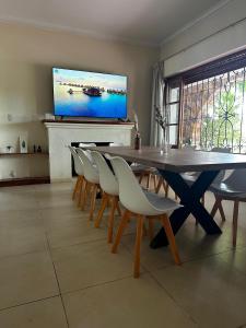 uma sala de jantar com mesa e cadeiras e uma televisão de ecrã plano em Cervantes - Casa de huespedes - Chacras de Coria em Ciudad Lujan de Cuyo