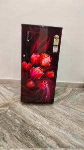 einen Kühlschrank mit einem Bild von roten Blumen darauf in der Unterkunft Hotel Kashyaam Inn in Varanasi
