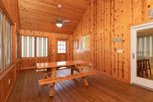 uma cabina de madeira com uma mesa de madeira num quarto em Tranquility Beach House - Beautiful cape cod style home just a short walk to Oak Street beach access em South Haven