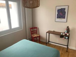 Schlafzimmer mit einem Bett, einem Schreibtisch und einem Stuhl in der Unterkunft Grande maison à 5 minutes des plages in La Rochelle