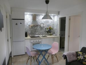 eine Küche mit einem Tisch und 2 rosa Stühlen in der Unterkunft Casita con encanto en Baiona a lado de las playas de Santa Marta y Ladeira in Baiona