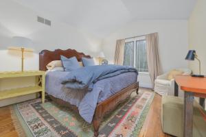 1 dormitorio con cama, escritorio y ventana en Tranquility - New Vacation Rental - Large home perfect for a relaxing getaway!, en Fennville