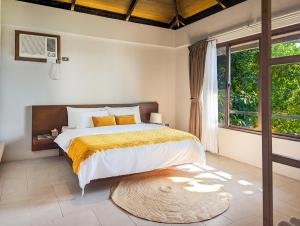 a bedroom with a bed and a large window at Perch El Nido's Seaview Villas Marimegmeg Beach in El Nido