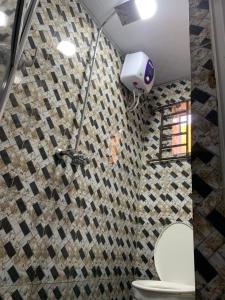 a bathroom with a toilet and a wall at Lagos 1-Bed Apt Sleeps 2 with AirCon & Parking in Lagos +18 photos