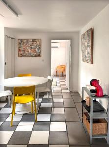 ein Esszimmer mit einem Tisch und gelben Stühlen in der Unterkunft VILLA ARVOR CANNES Appartement indépendant en bas de maison in Cannes