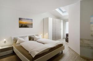 a bedroom with a large bed with white walls at Opashus in Borkum